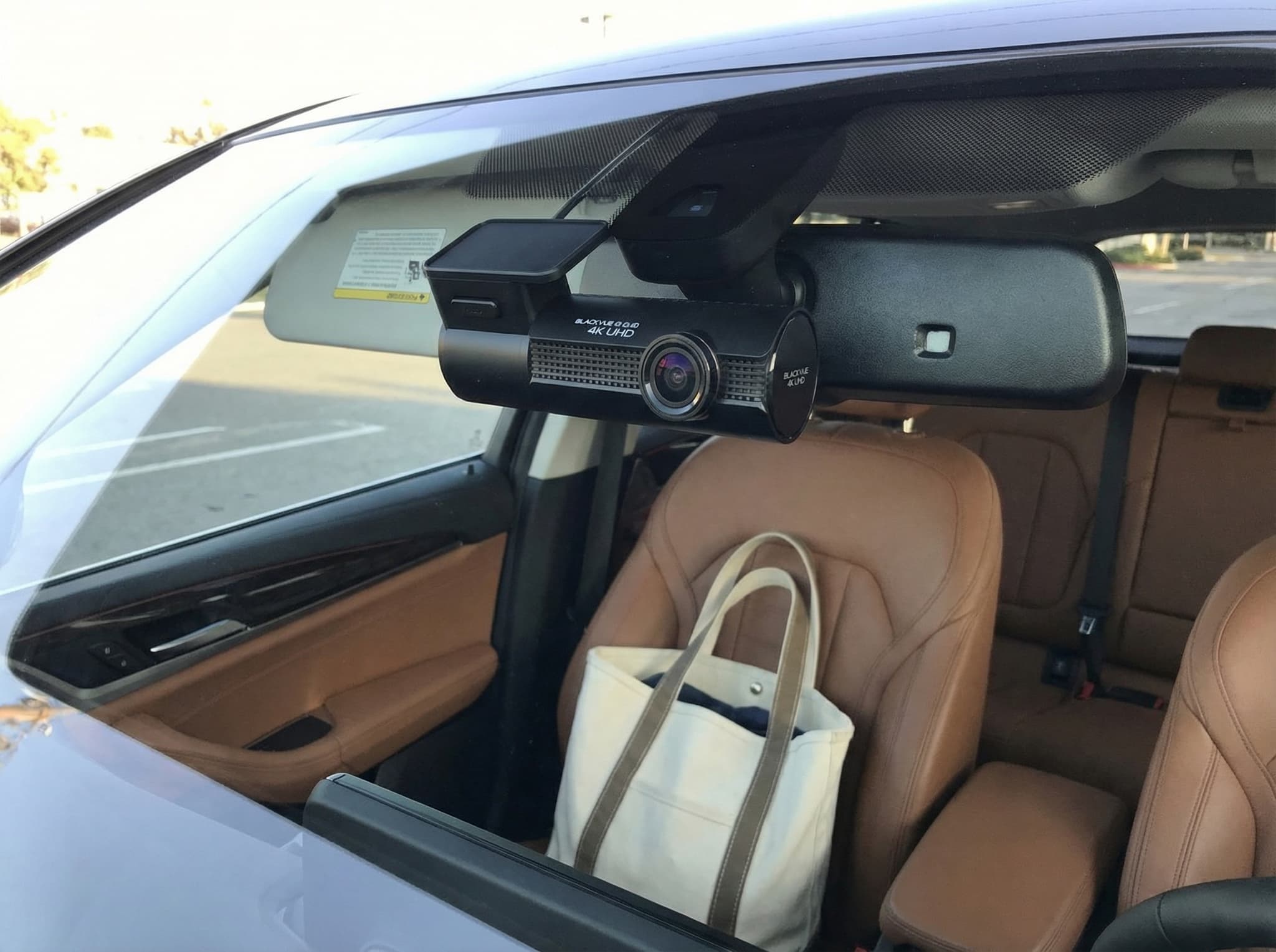 BlackVue Elite 9-2CH cylindrical dash cam mounted behind rearview mirror with cloud connectivity indicator